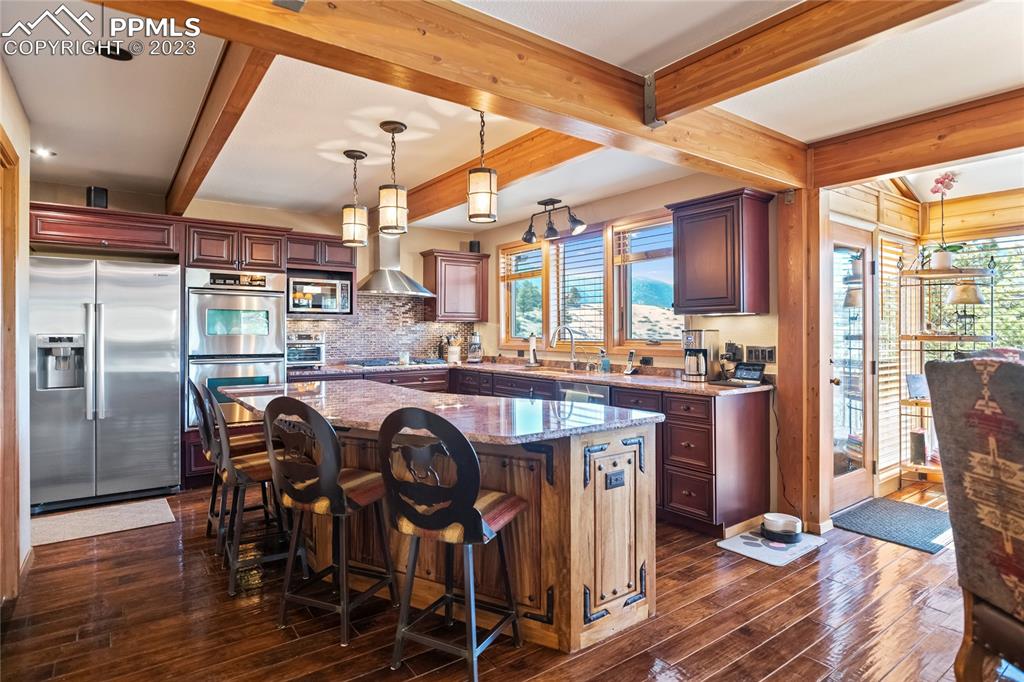4528 Sheep Patch Road Golden, CO 80403 - Photo 11 of 40 a kitchen with stainless steel appliances granite countertop a table chairs and a refrigerator