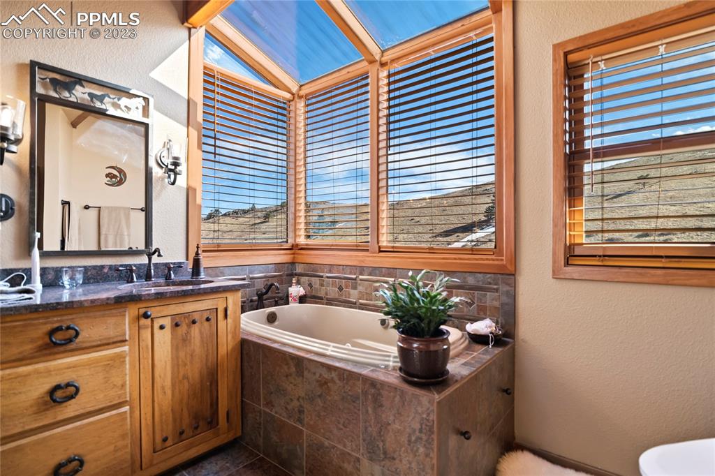 4528 Sheep Patch Road Golden, CO 80403 - Photo 23 of 40 a bathroom with a sink a mirror and a window