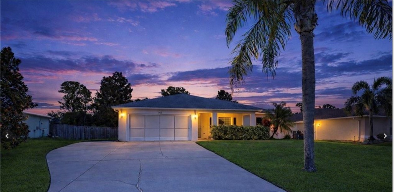 a front view of a house with a garden and yard
