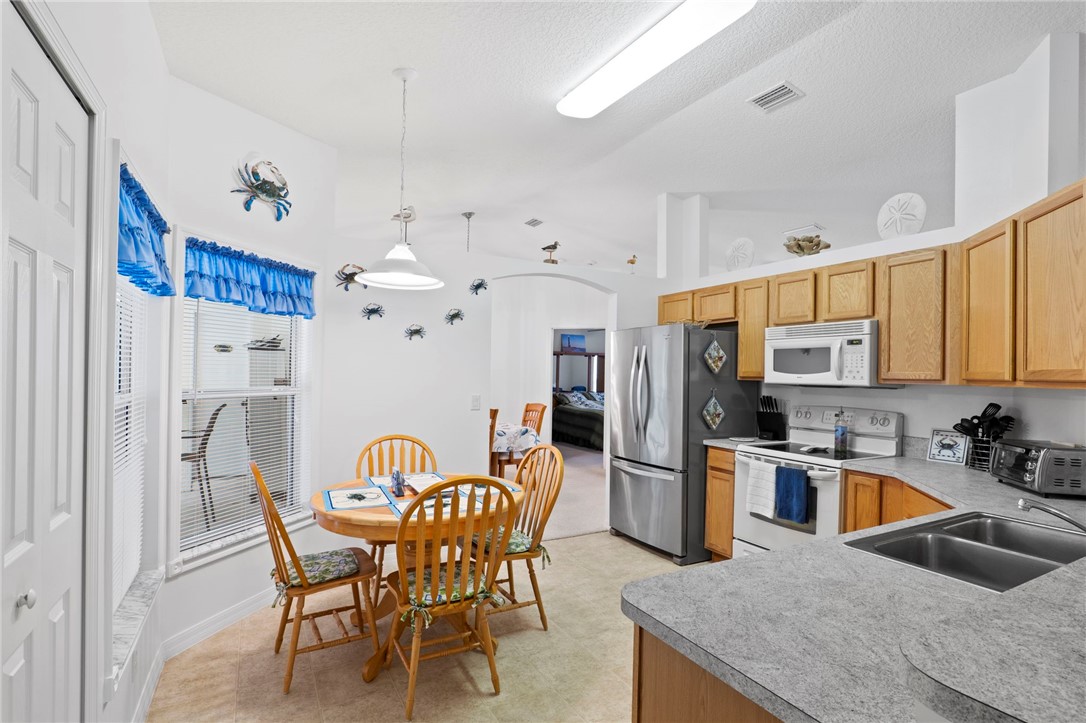934 Bermuda Avenue Sebastian, FL 32958 - Photo 13 of 31 a kitchen with stainless steel appliances granite countertop a dining table and chairs