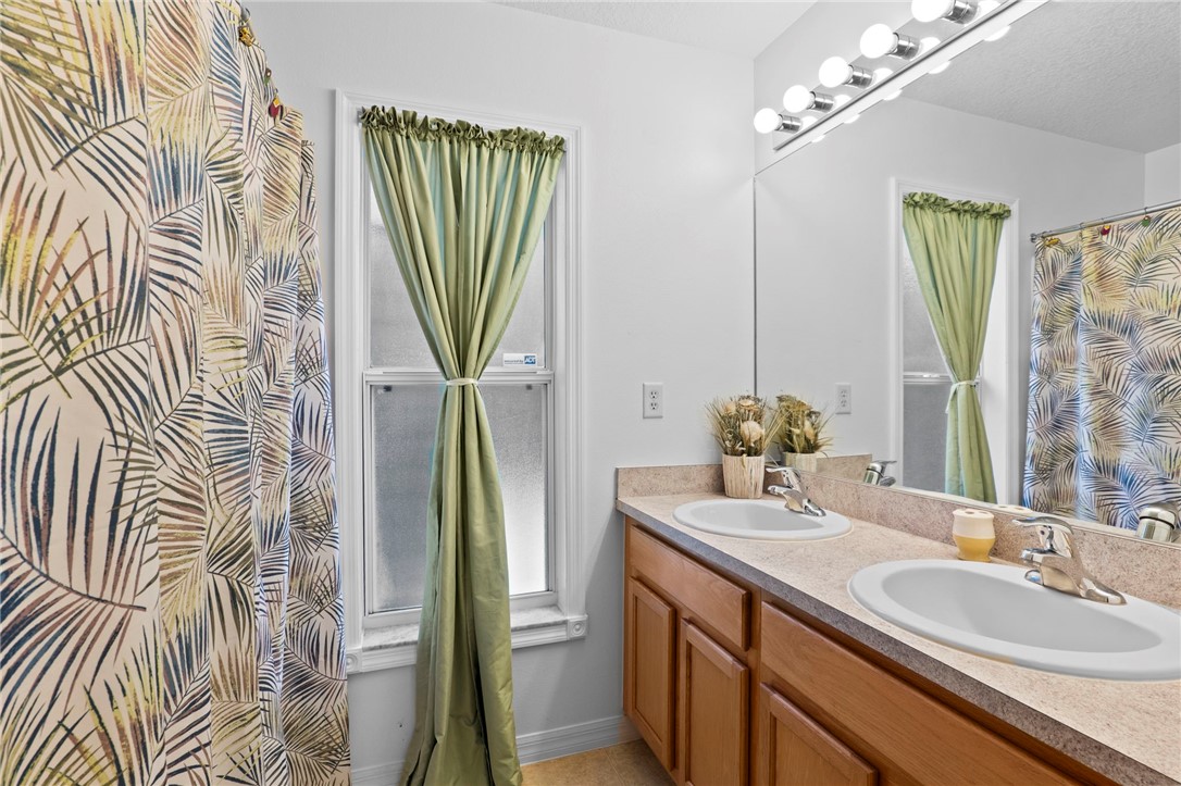 934 Bermuda Avenue Sebastian, FL 32958 - Photo 17 of 31 a bathroom with a sink a mirror and a shower curtain