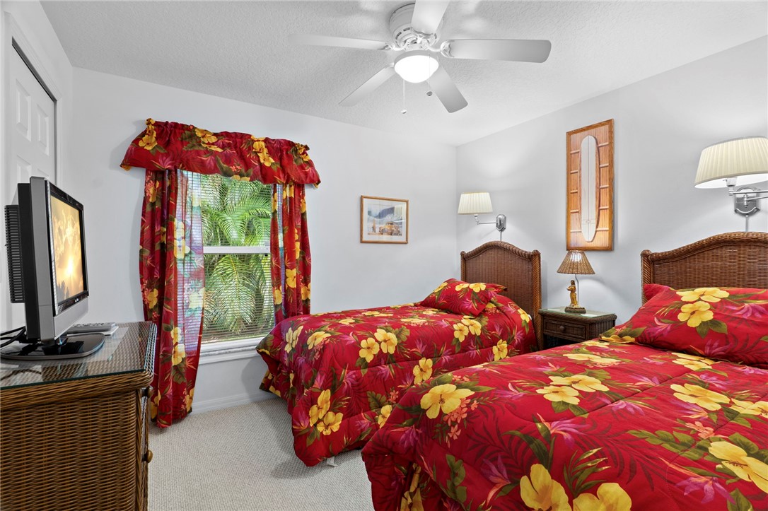 934 Bermuda Avenue Sebastian, FL 32958 - Photo 25 of 31 a bedroom with two beds and a chandelier