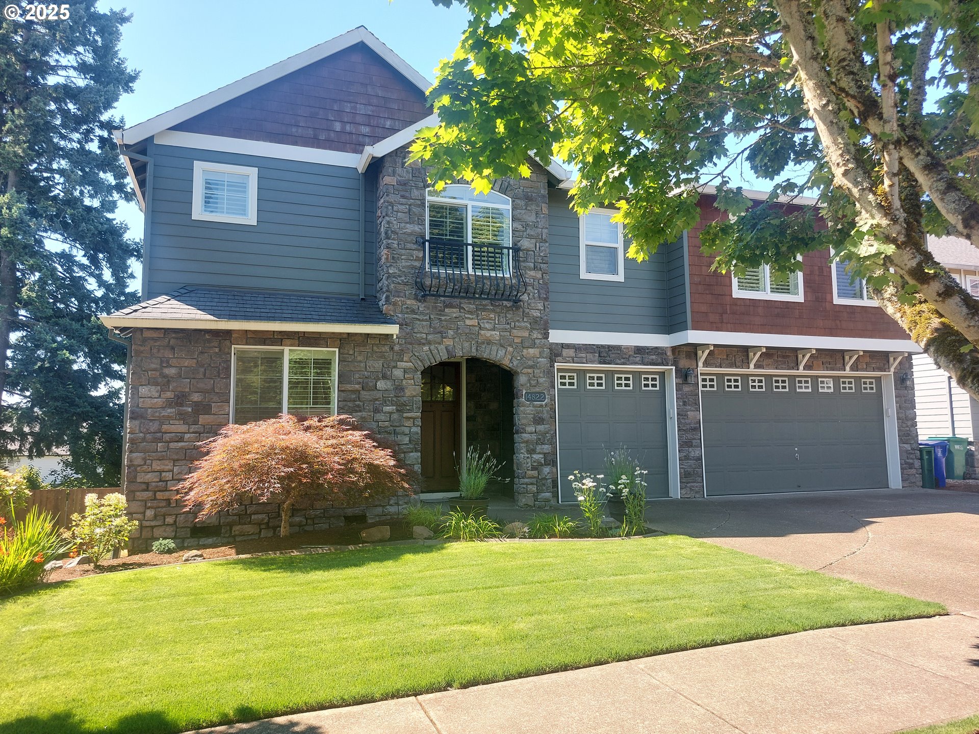 a front view of a house with a garden and trees