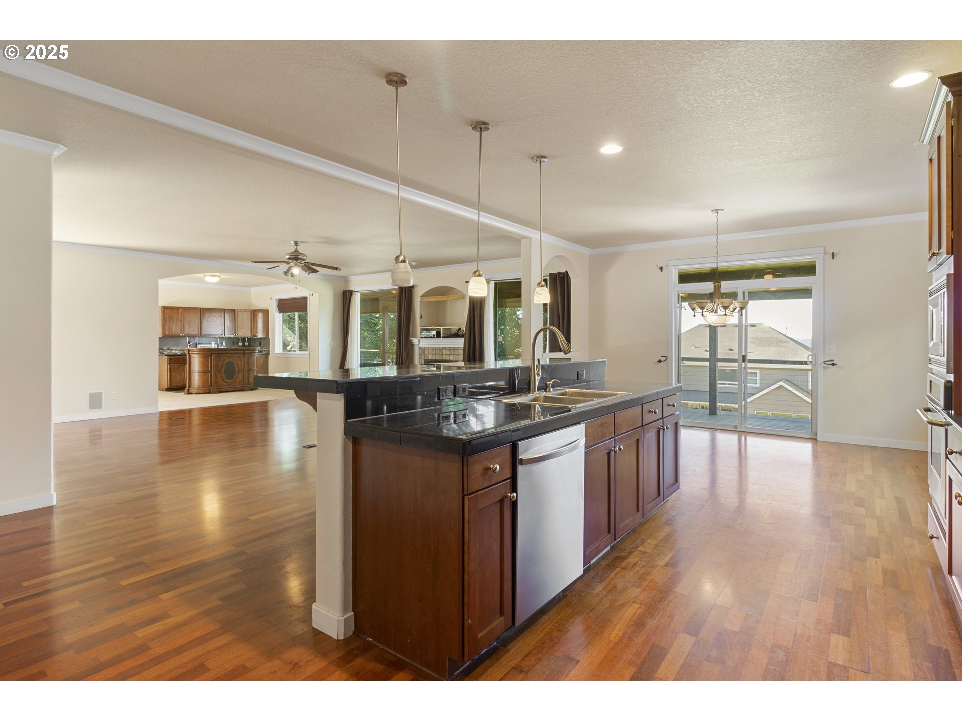 14822 Southeast Natalya Street Happy Valley, OR 97086 - Photo 18 of 48 a open kitchen with granite countertop a stove top oven a sink with wooden cabinets and wooden floor