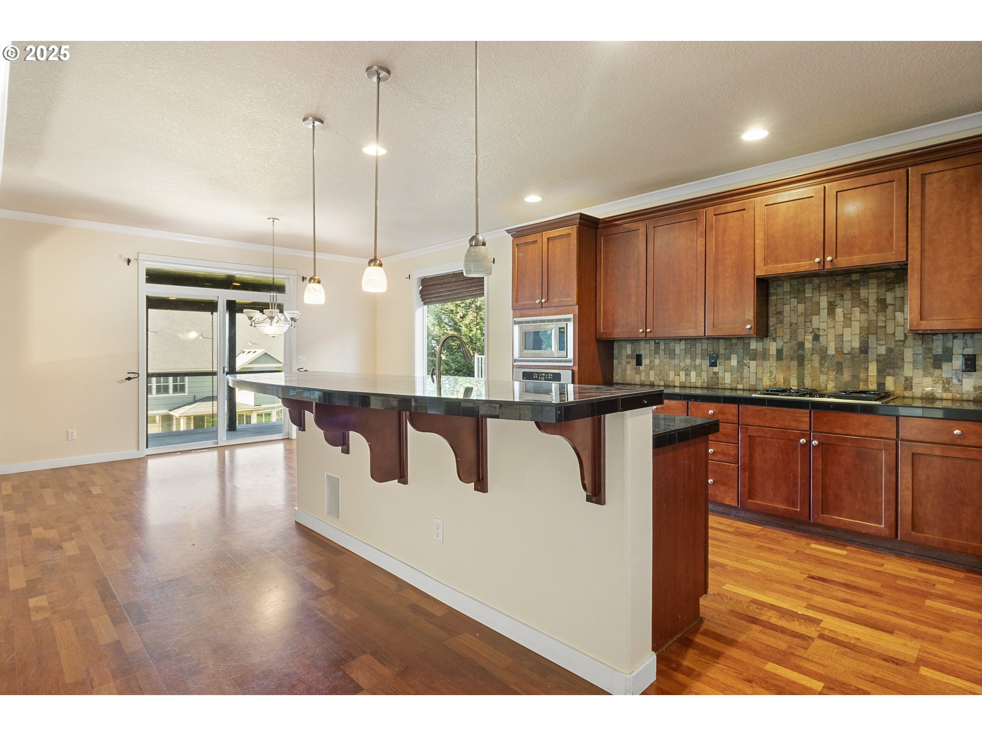14822 Southeast Natalya Street Happy Valley, OR 97086 - Photo 19 of 48 a kitchen with kitchen island granite countertop wooden floors and view of living room
