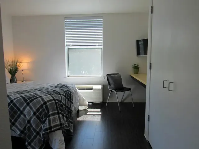 a bedroom with a bed and a window