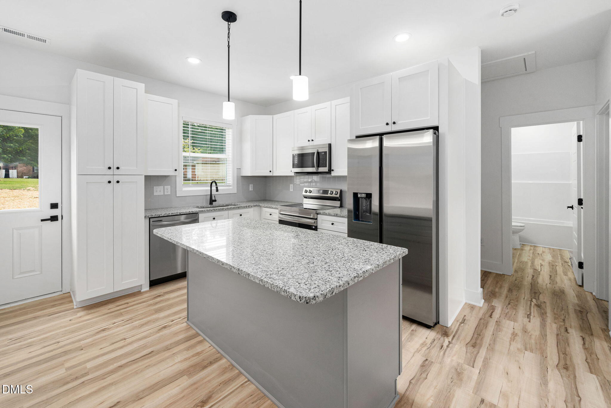 305 West Barden Street Roxboro, NC 27573 - Photo 15 of 31 a kitchen with stainless steel appliances granite countertop a refrigerator a sink dishwasher a stove and white cabinets with wooden floor