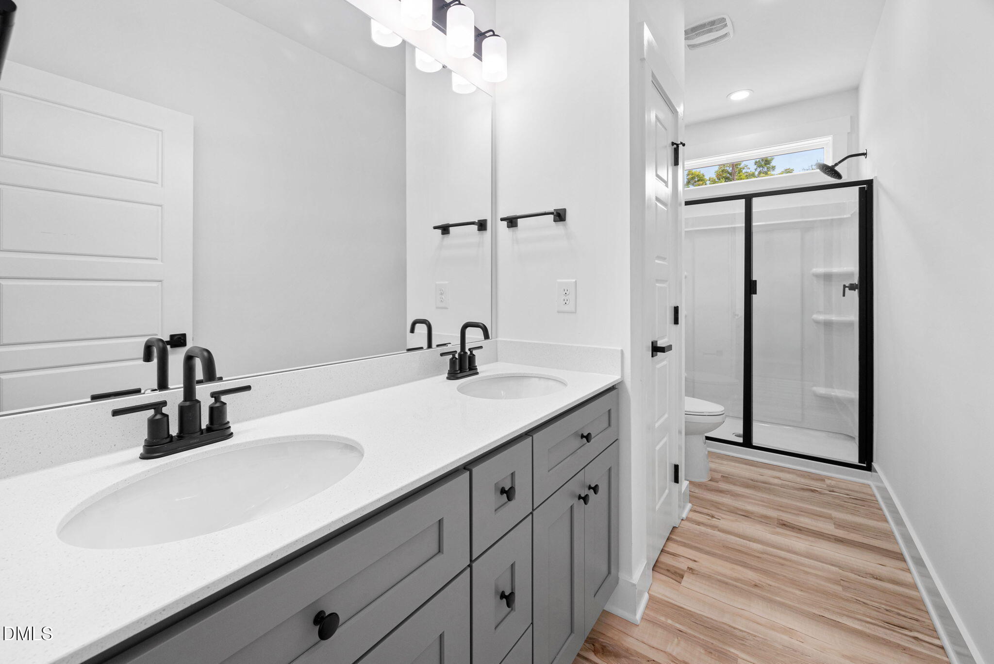 305 West Barden Street Roxboro, NC 27573 - Photo 23 of 31 a bathroom with a double vanity sink a mirror and shower