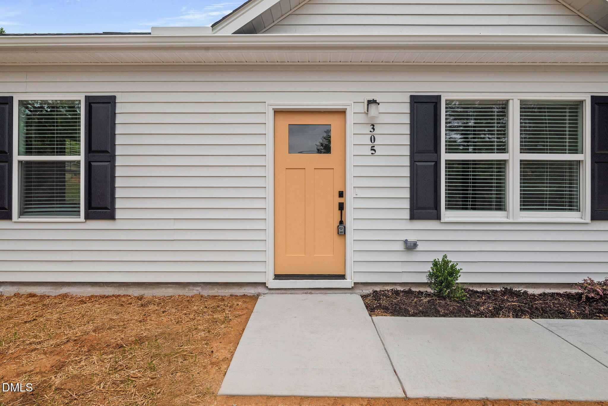 305 West Barden Street Roxboro, NC 27573 - Photo 4 of 31 a side view of a house with a yard and potted plants
