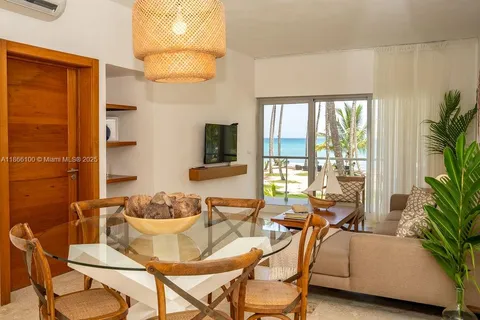 a dining room with furniture and a potted plant