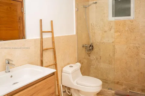 a bathroom with a sink a toilet and shower