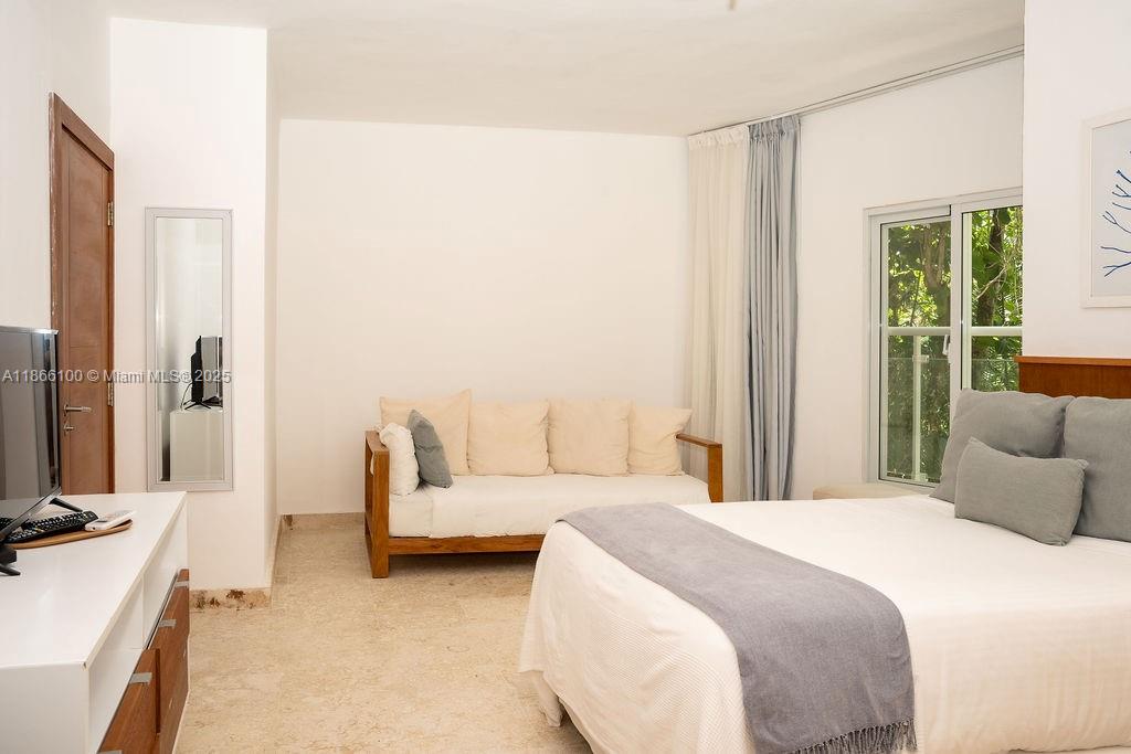 0 8c3f Q62 Las Terrenas Drive, Unit 2 Las Terrenas, Samaná Province 32000 - Photo 20 of 38 a bedroom with a bed couch and a large window