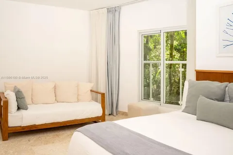 a bedroom with furniture and a large window