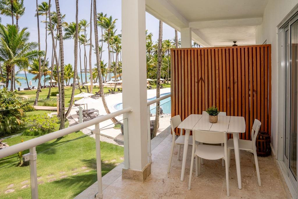 0 8c3f Q62 Las Terrenas Drive, Unit 2 Las Terrenas, Samaná Province 32000 - Photo 33 of 38 a dining room with furniture and a floor to ceiling window