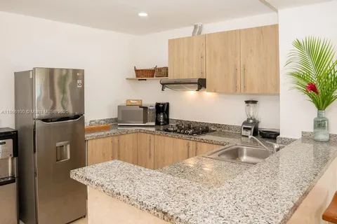 a kitchen with granite countertop a sink refrigerator and microwave