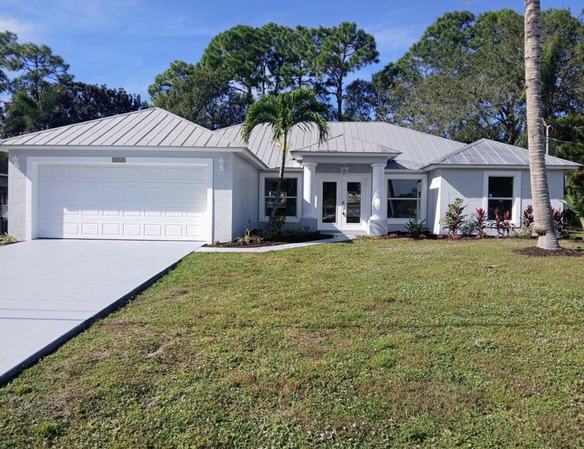 3450 Southwest Martin Street Port St. Lucie, FL 34953 - Photo 1 of 7 a front view of a house with garden