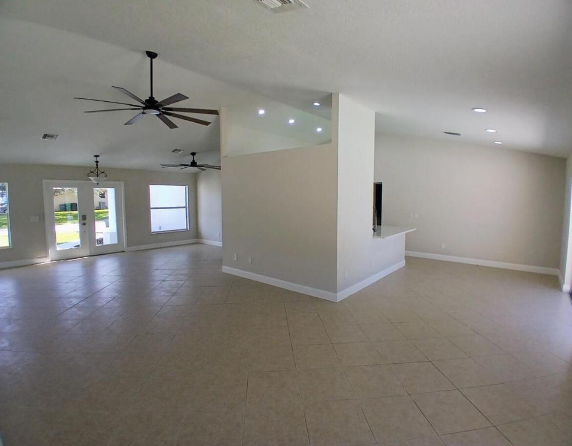 3450 Southwest Martin Street Port St. Lucie, FL 34953 - Photo 5 of 7 an empty room with windows and ceiling fan