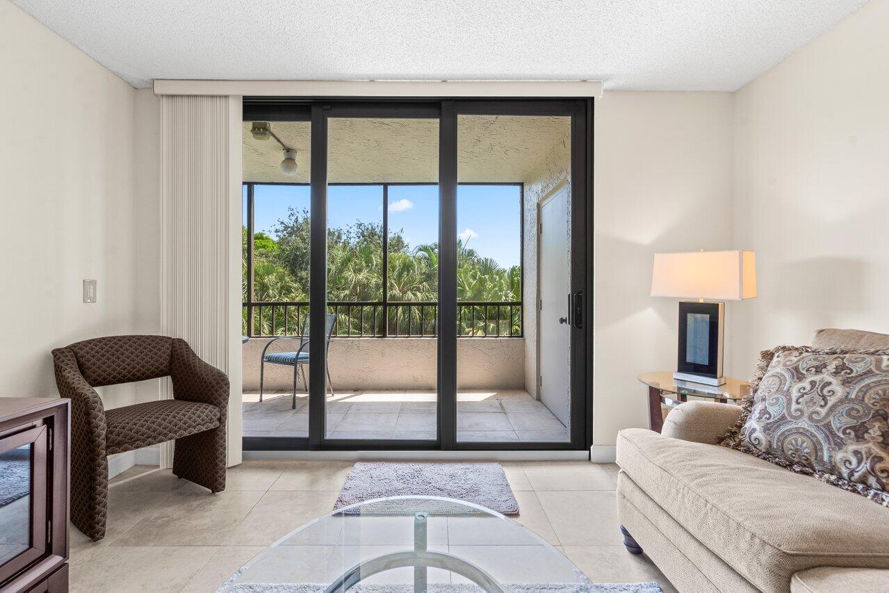 2070 Homewood Boulevard, Unit 4140 Delray Beach, FL 33445 - Photo 12 of 28 a living room with furniture and a floor to ceiling window