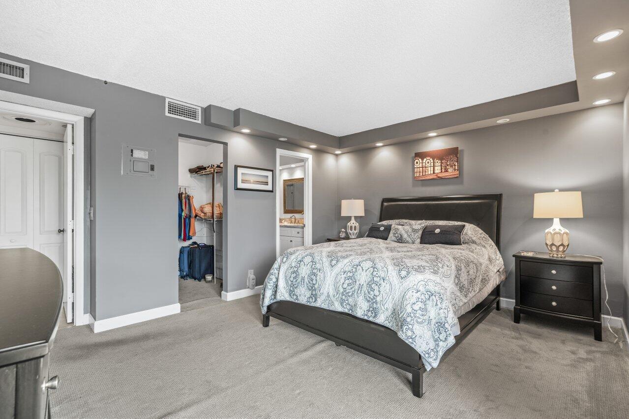 2070 Homewood Boulevard, Unit 4140 Delray Beach, FL 33445 - Photo 14 of 28 a spacious bedroom with a bed and a lamp