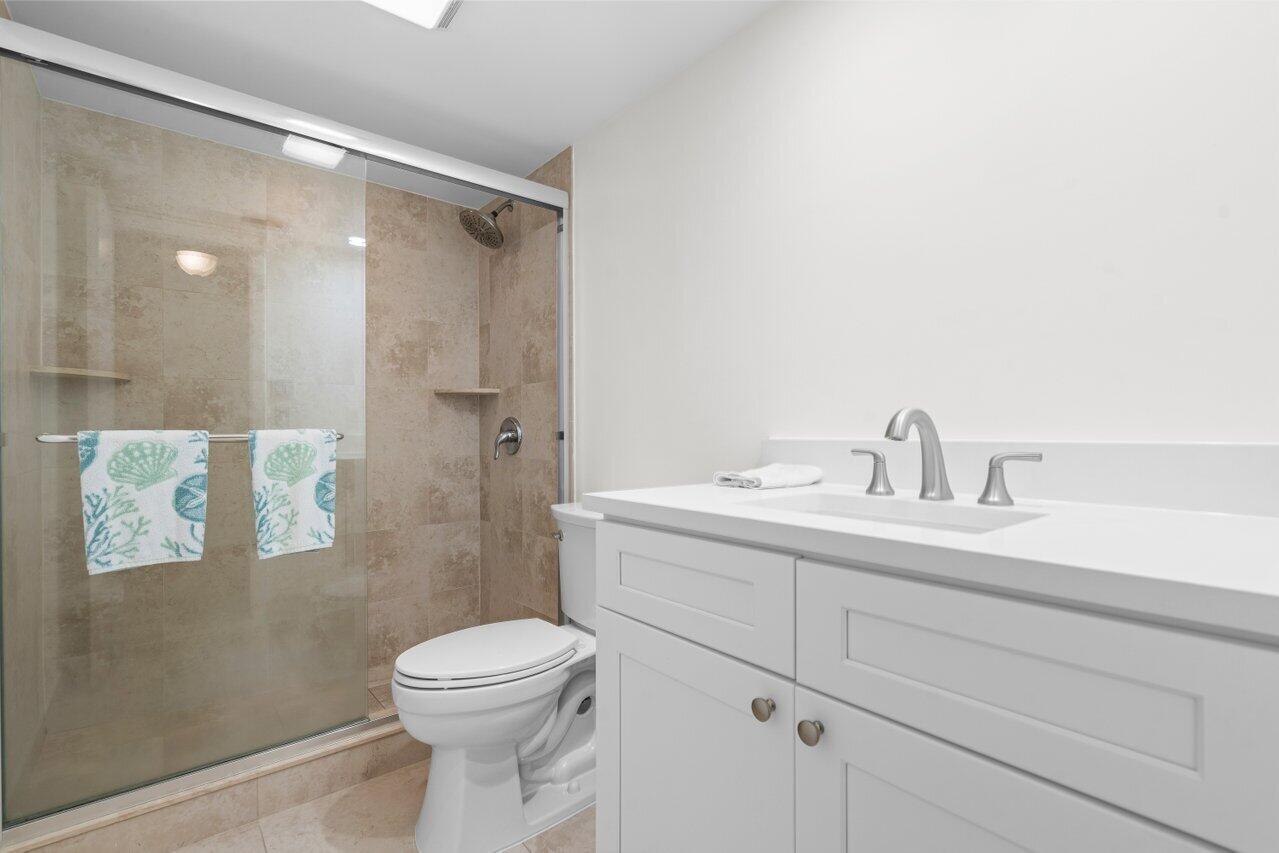 2070 Homewood Boulevard, Unit 4140 Delray Beach, FL 33445 - Photo 19 of 28 a bathroom with a sink a toilet and shower
