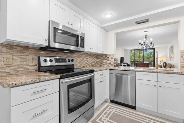 a kitchen with stainless steel appliances granite countertop a stove a microwave and cabinets