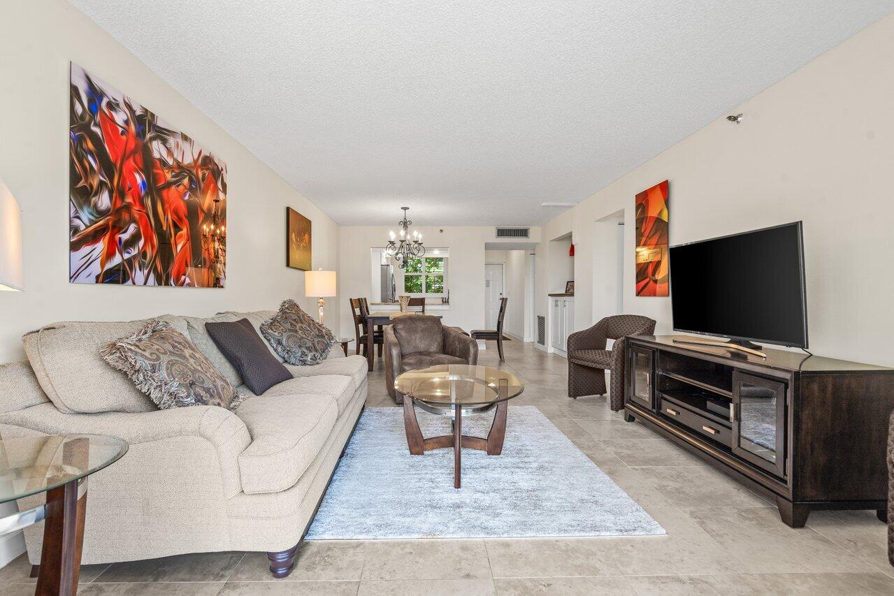 2070 Homewood Boulevard, Unit 4140 Delray Beach, FL 33445 - Photo 9 of 28 a living room with furniture and a flat screen tv
