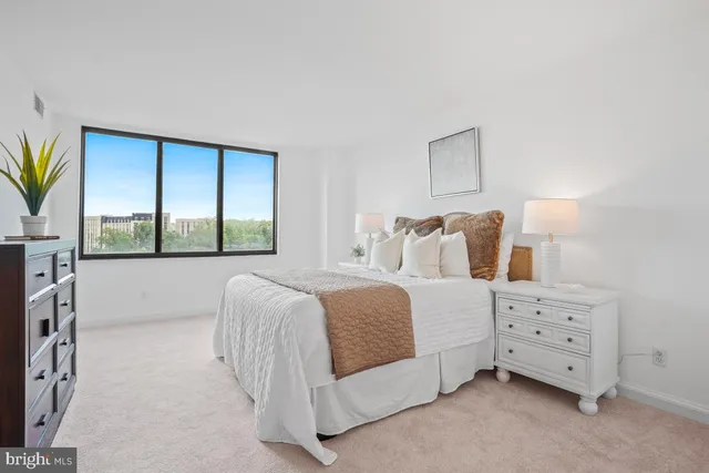 a bedroom with a bed and a large window