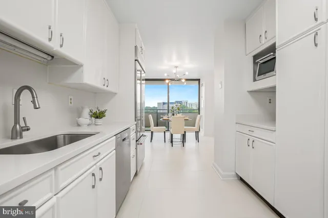 a kitchen with white cabinets and appliances