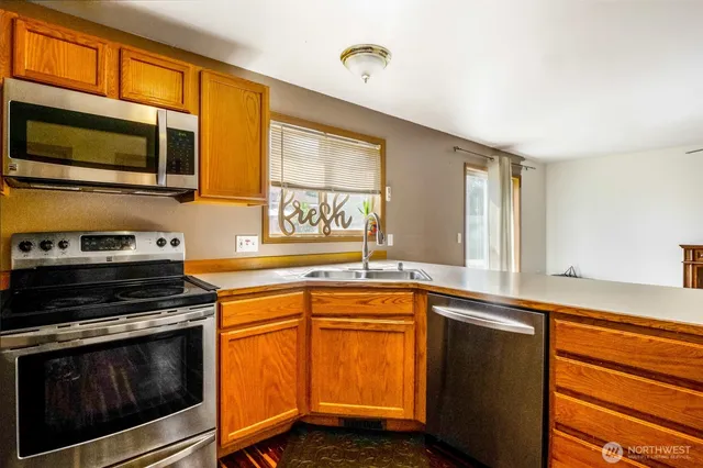a kitchen with stainless steel appliances a stove microwave and sink