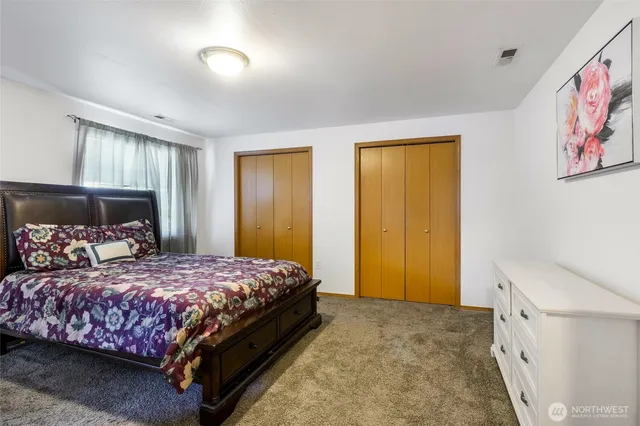 a bedroom with a bed and a painting on the wall