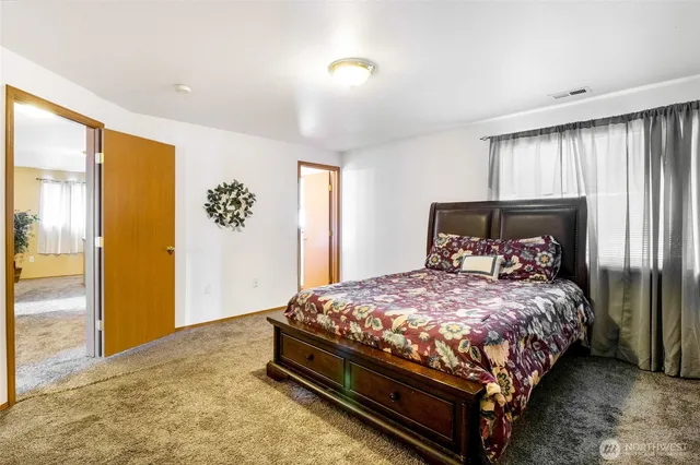 a large bed sitting in a room next to a window