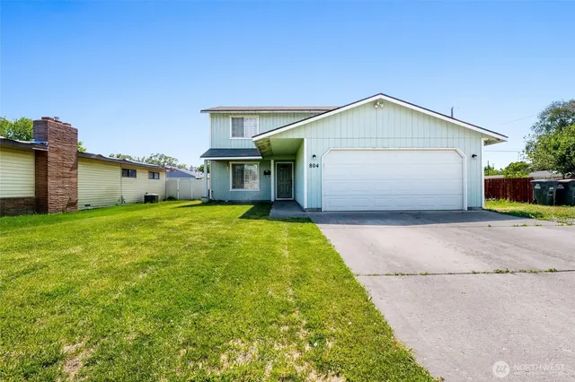 a front view of house with yard and garage