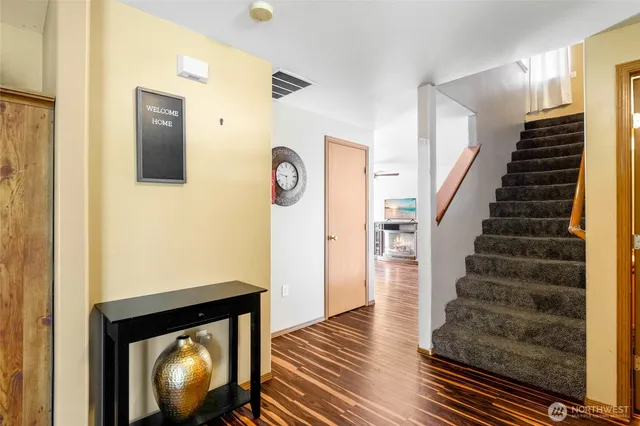 a view of entryway and hall with wooden floor
