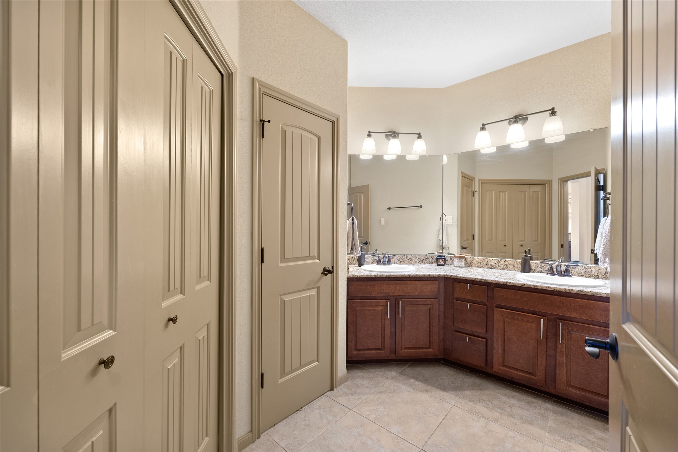 1690 Hickory Creek Road Marble Falls, TX 78654 - Photo 12 of 25 Bathroom with a closet, double vanity, and light tile patterned floors