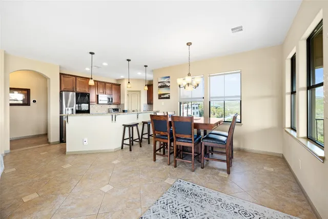 a view of a dining room and livingroom with furniture wooden floor a rug a fireplace