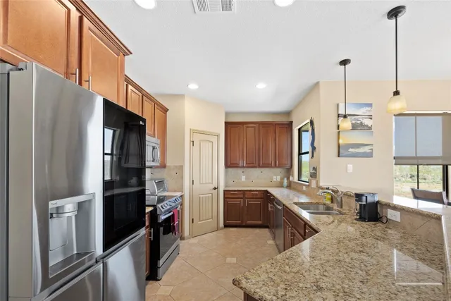 a kitchen with stainless steel appliances granite countertop a refrigerator and a sink