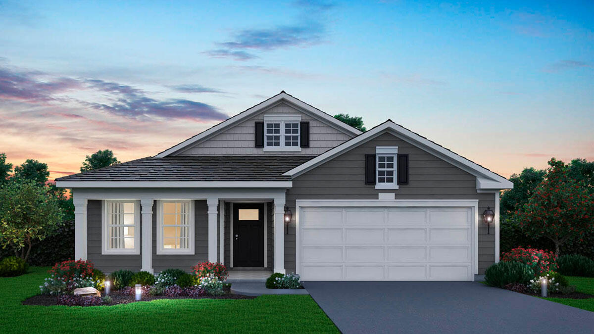 a front view of a house with a garden and plants