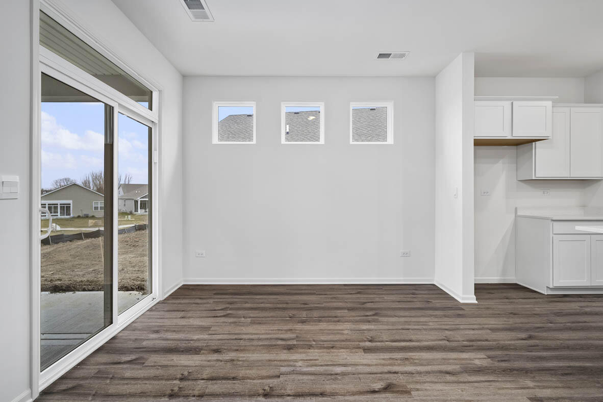 7676 West 106th Place Crown Point, IN 46307 - Photo 8 of 13 a view of an empty room with wooden floor and a window