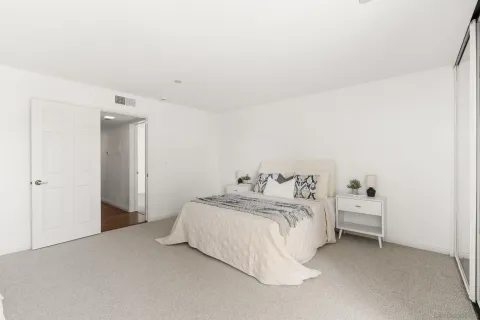 a bedroom with a bed and a night stand