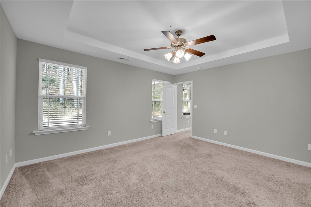 138 Madison Pointe Drive Seneca, SC 29678 - Photo 18 of 42 This spacious bedroom offers comfortable carpeting, ample natural light, and a stylish ceiling fan.
