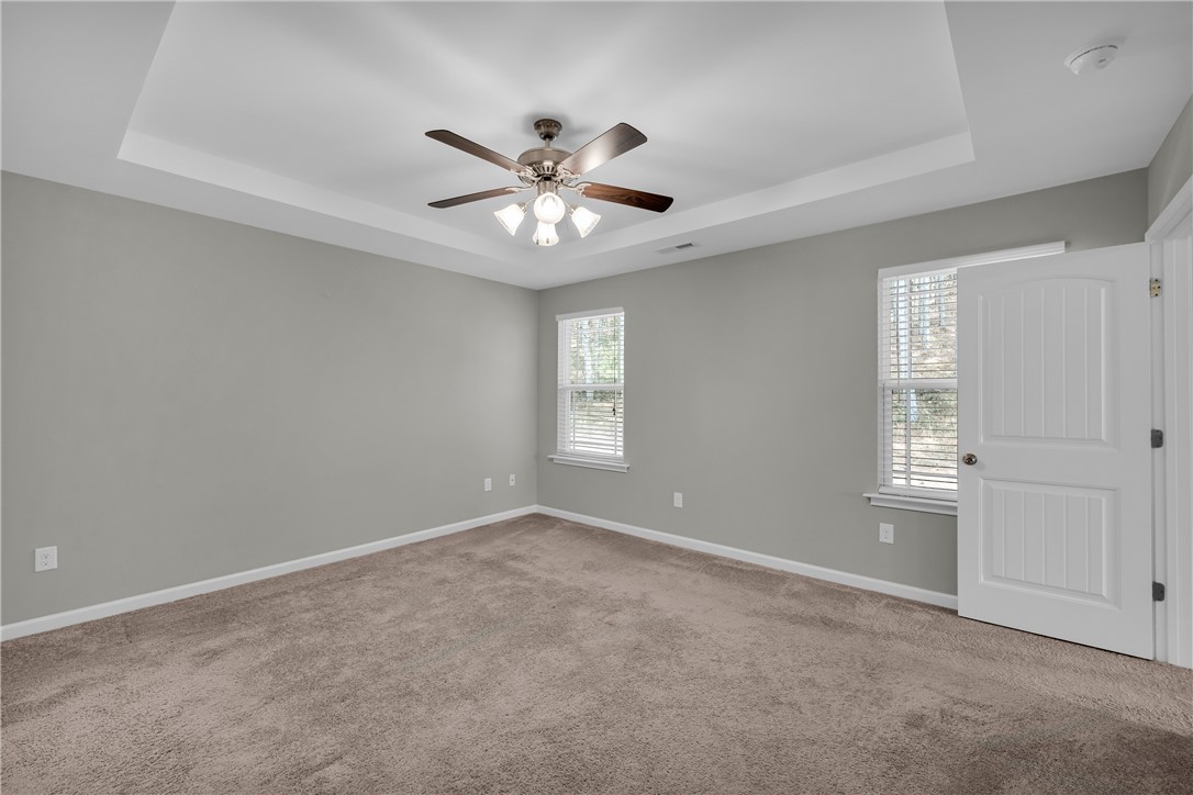 138 Madison Pointe Drive Seneca, SC 29678 - Photo 19 of 42 This inviting bedroom features a cozy carpeted floor and a practical ceiling fan for year-round comfort.