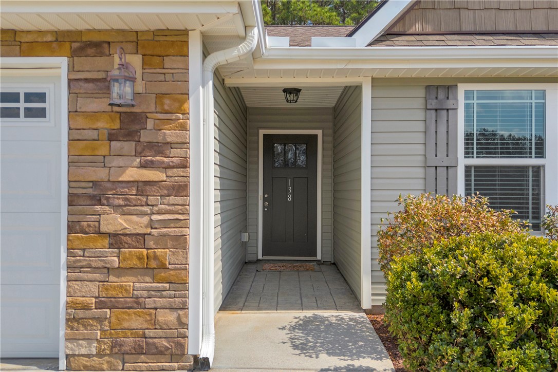 138 Madison Pointe Drive Seneca, SC 29678 - Photo 3 of 42 The inviting entrance features a dark door and tasteful stone accents, enhancing the home's charm.