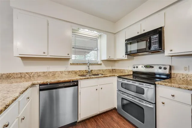 a kitchen with granite countertop white cabinets and appliances