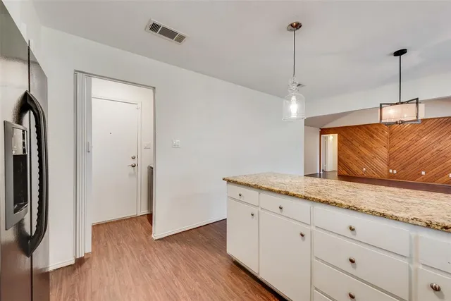 a hallway with a granite countertop sink and a refrigerator