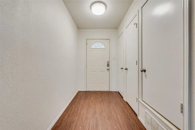 a view of a hallway with wooden floor