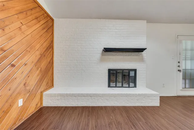 a living room with a fireplace and wooden floor