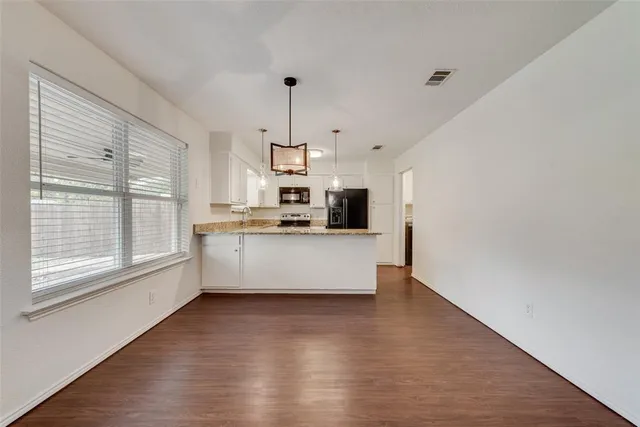 a large kitchen with kitchen island a large counter top space and stainless steel appliances