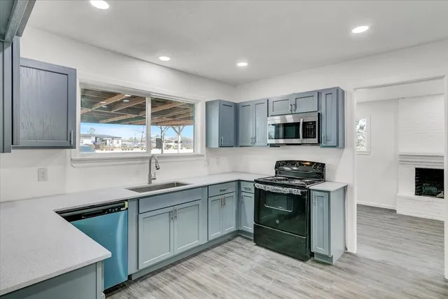 a kitchen with stainless steel appliances granite countertop a sink stove oven and wooden cabinets