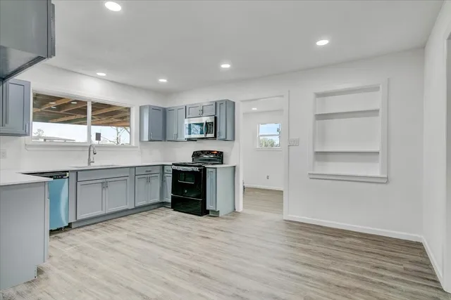 a large kitchen with stainless steel appliances granite countertop a stove and a sink