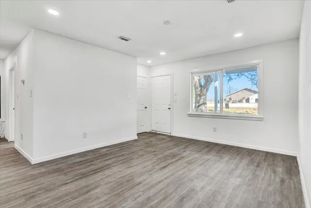 a view of an empty room with wooden floor
